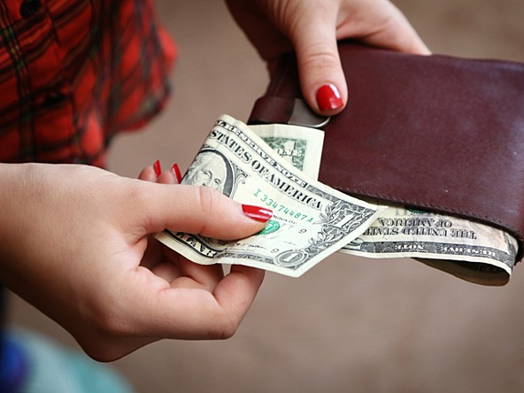 woman using wallet with dollars